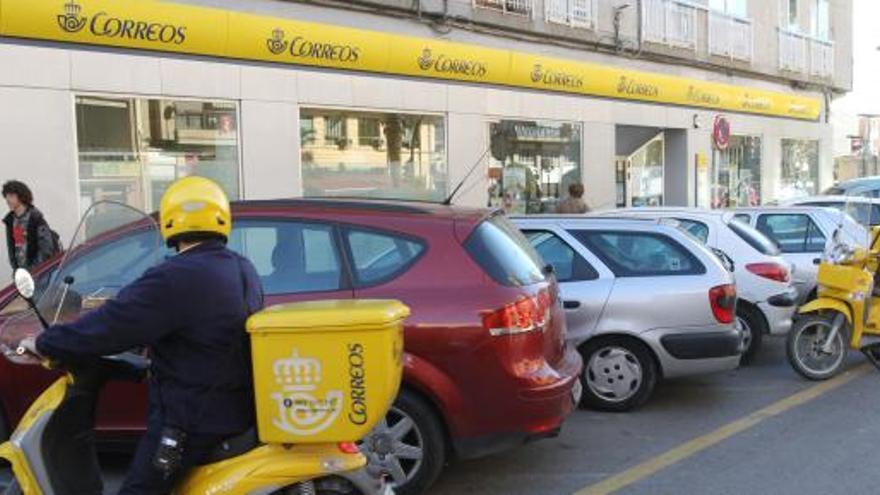 Un empledo de Correos realiza su reparto.