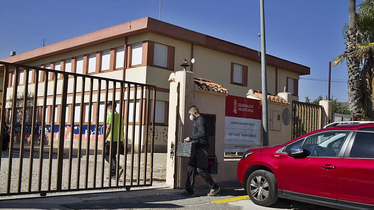 Dos operarios acceden al CEIP Vicente Blasco Ibáñez de Montesa, ayer a mediodía.