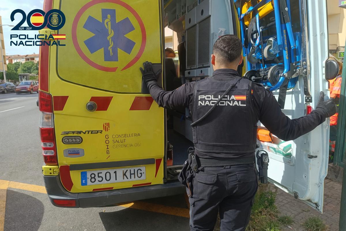 Un agente de la Policía Naciona, junto a una ambulancia.