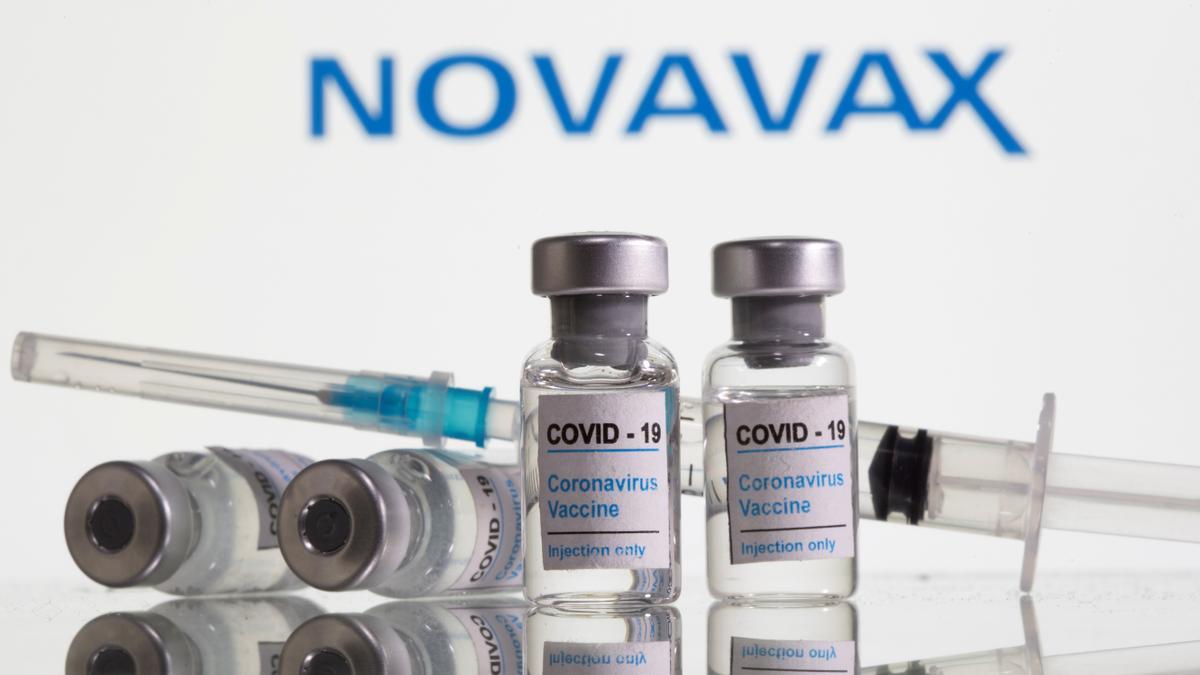 FILE PHOTO: Vials labelled &quot;COVID-19 Coronavirus Vaccine&quot; and sryinge are seen in front of displayed Novavax logo in this illustration