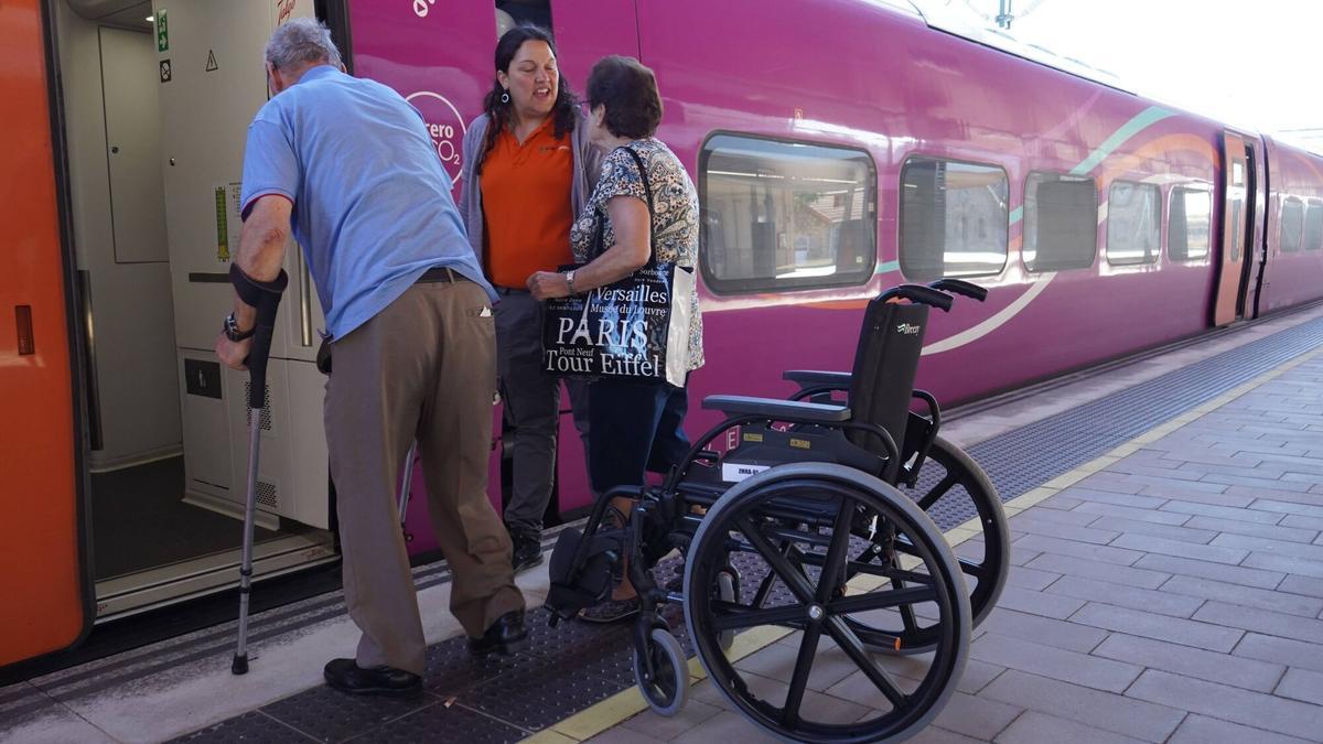 Un viajero con movilidad reducida recibe asistencia para el viaje.