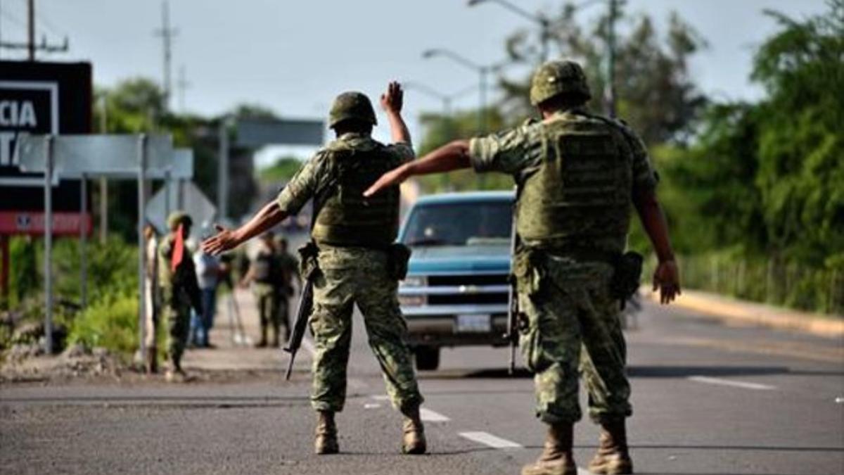 El elocuente titular de portada del diario 'La Prensa' tras la fuga. Abajo, un control militar en la autopista Badiraguato-Santiago de Los Caballeros, en Sinaloa.