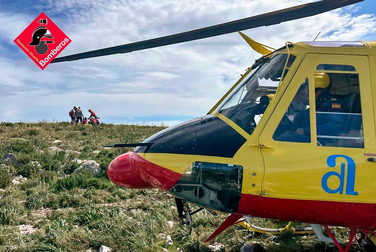 El helicóptero en primer término y, al fondo, los rescatadores y los excursionistas de la Serra del Migdia de Pego
