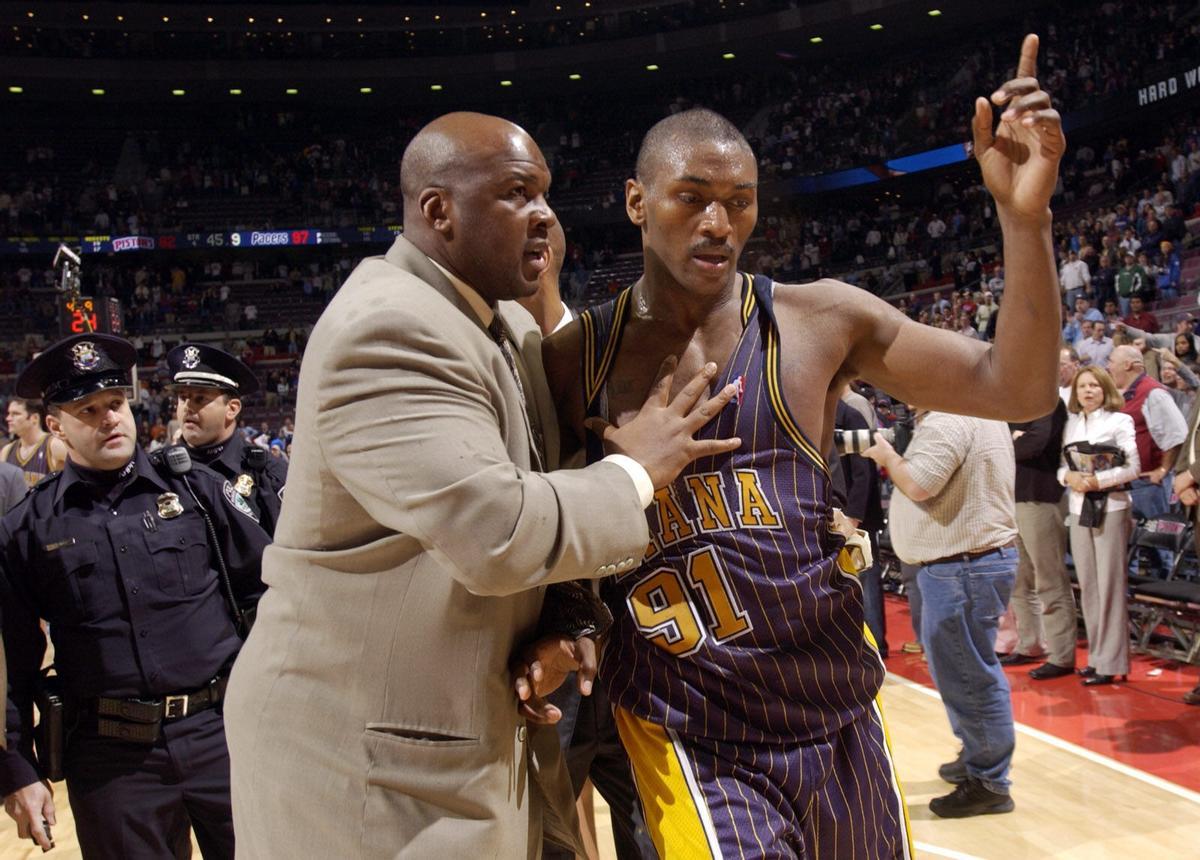 Indiana Pacers' Ron Artest is led off the court by Pacers special consultant Chuck Person after a brawl near the end of the game against the Detroit Pistons in Auburn Hills, Mich., Friday, Nov. 19, 2004. Artest and teammate Stephen Jackson charged into the crowd and fought with fans in the final minute of the game, forcing an early end to the Pacers' 97-82 victory over the Pistons. (AP Photo/The Detroit News, Clarence Tabb, Jr.). HORIZONTAL