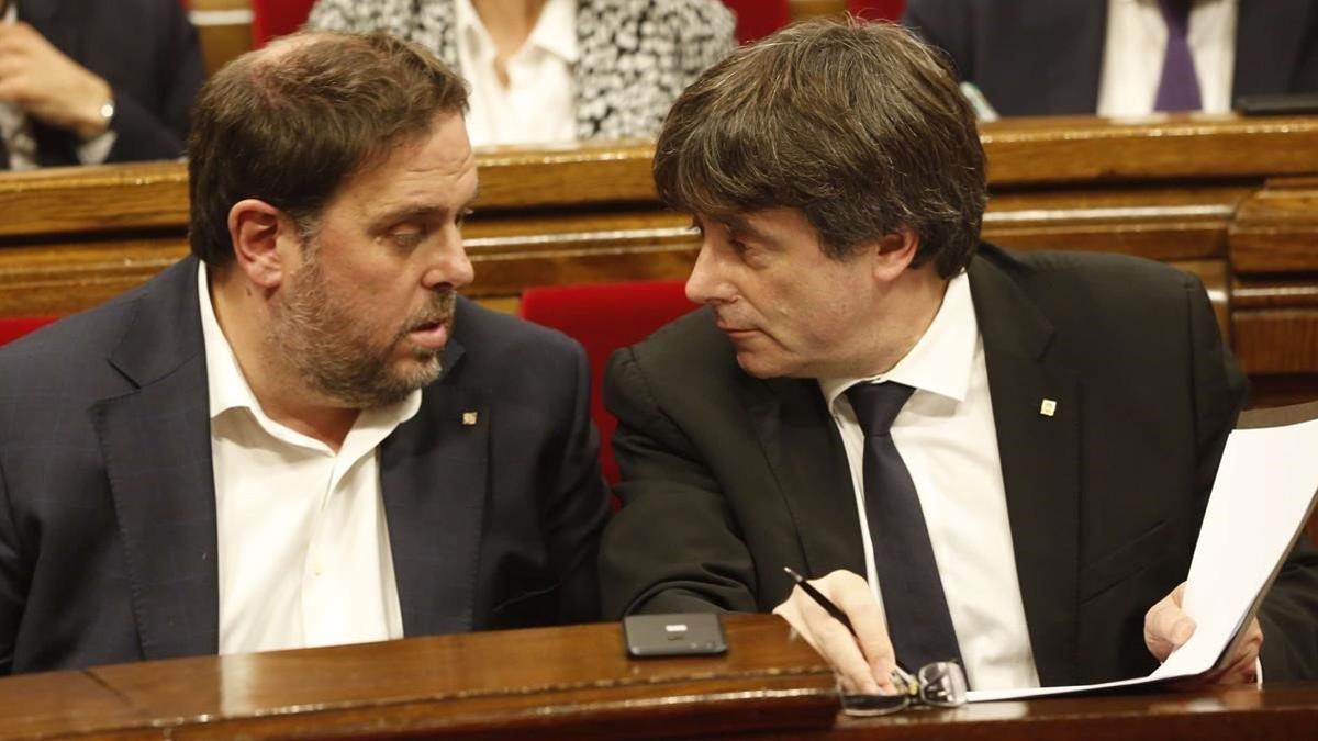 Carles Puigdemont y Oriol Junqueras durante un debate en el Parlament