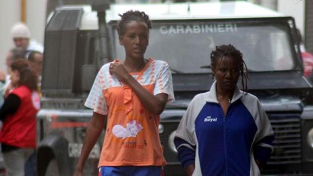 Dos mujeres caminan por el centro de recepción de inmigrantes de Lampedusa, este martes.