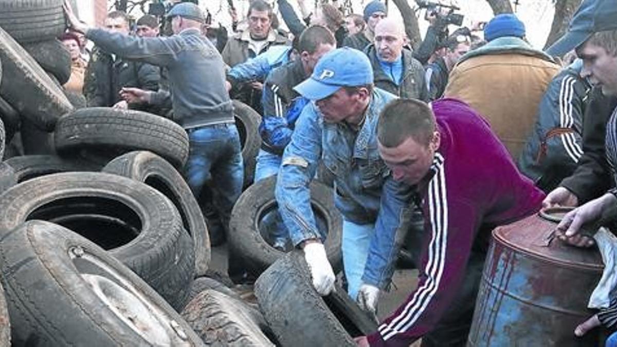 Activistas prorrusos montan barricadas delante de una puerta en el aeropuerto de Kramatorsk, ayer.