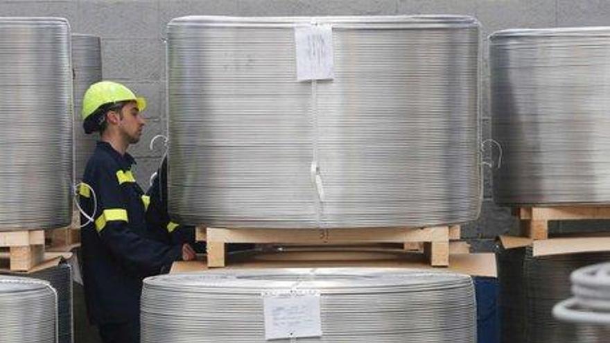 Un trabajador, ayer, manejando bobinas de alambrón en la fábrica.