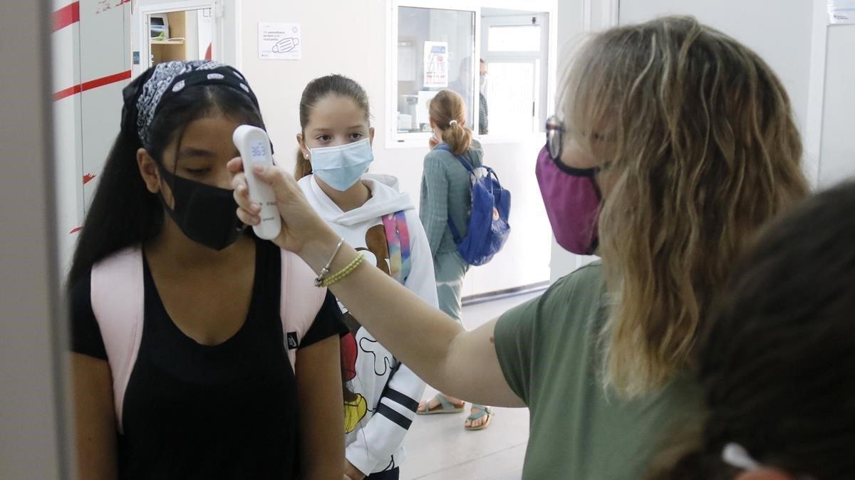 Una profesora toma la temperatura a una alumna de secundaria en el Institut Cinc Sénies de Mataró.