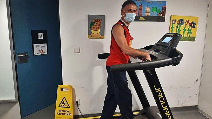 Un usuario practica con la cinta junto a la puerta de un aseo.   | // CENTRO JUAN MARÍA 