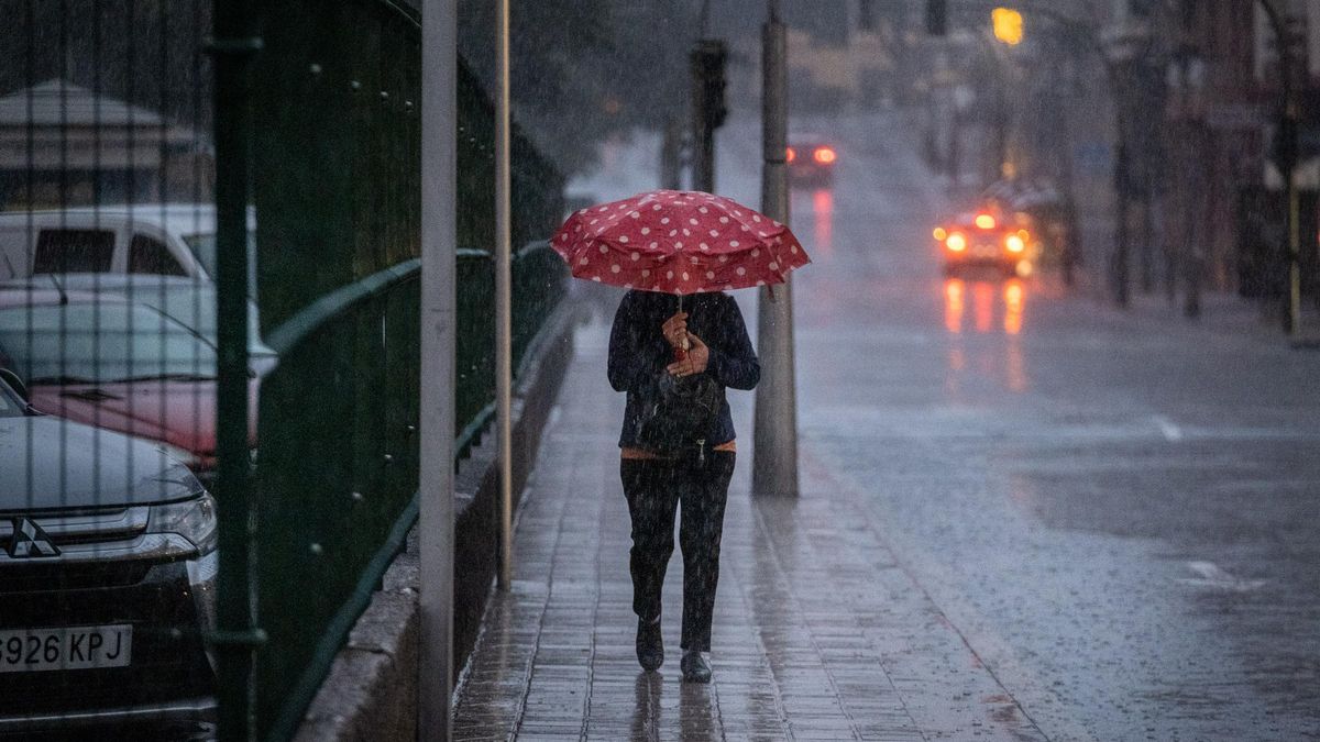 Una mujer se protege de la lluvia en Tenerife.
