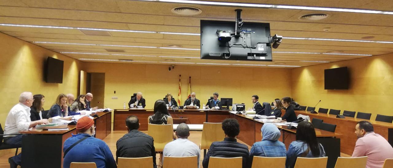 Els acusats (darrere) i la intèrpret (davant) durant el judici d&#039;una estafa a la Seguretat Social, a l&#039;Audiència de Girona.