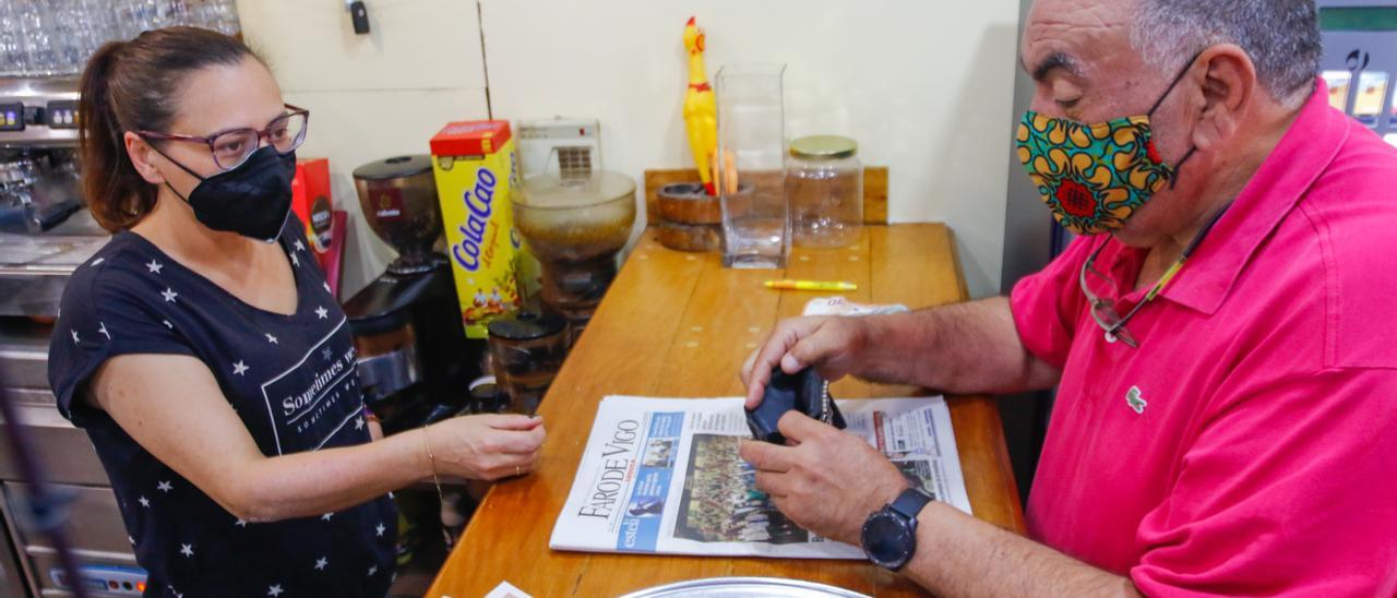 Un jubilado abona una consumición en un bar de Vilagarcía