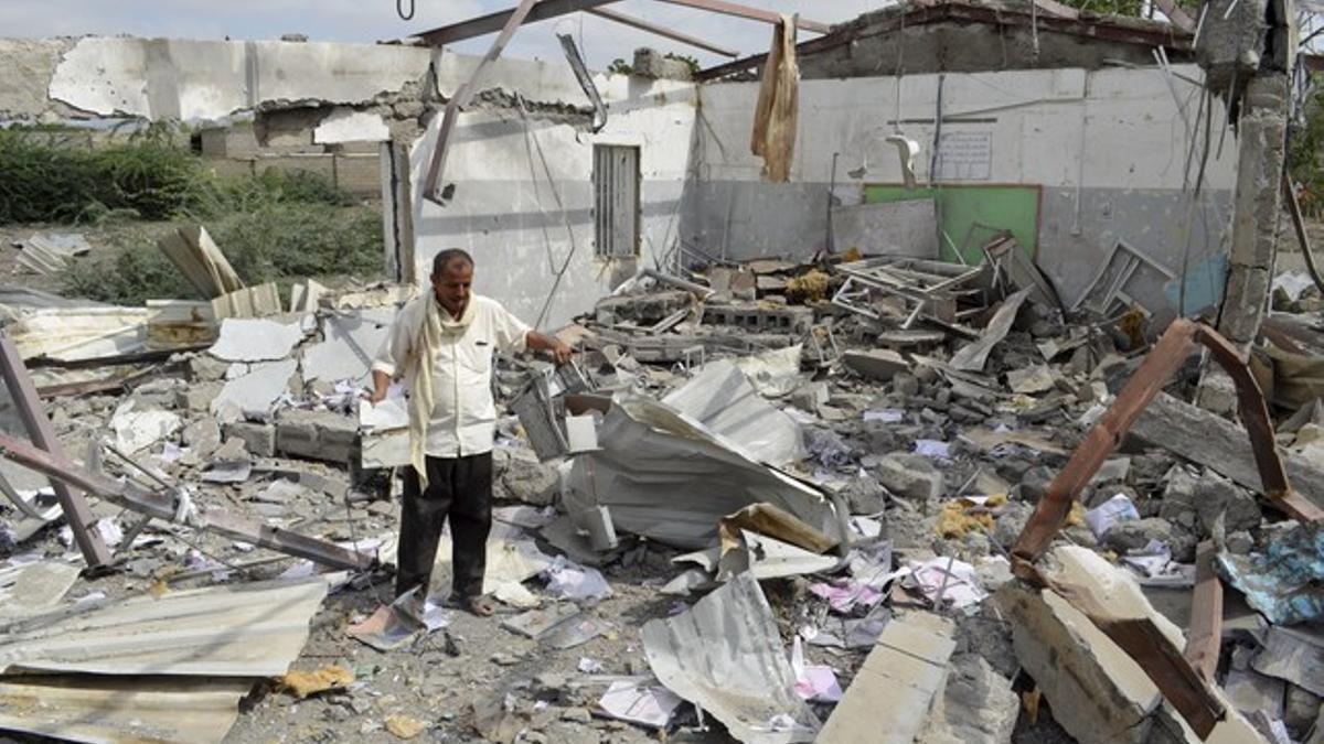 Un hombre intenta rescatar algunas pertenencias de un edificio en Bajil (Yemen) destruido por la coalición árabe.