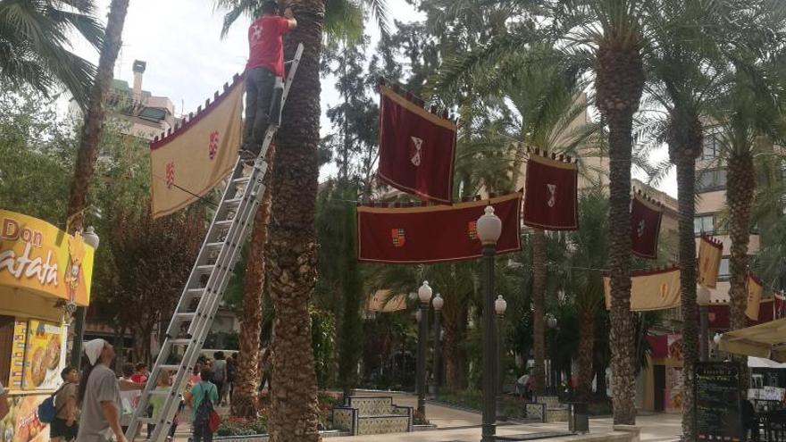 Operarios colocando pendones medievales en la Glorieta