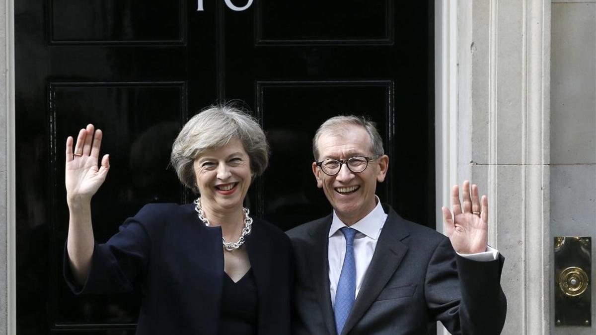 Theresa May y su esposo, Philip May, saludan en la entrada del número 10 de Downing Street, este miércoles, en Londres.