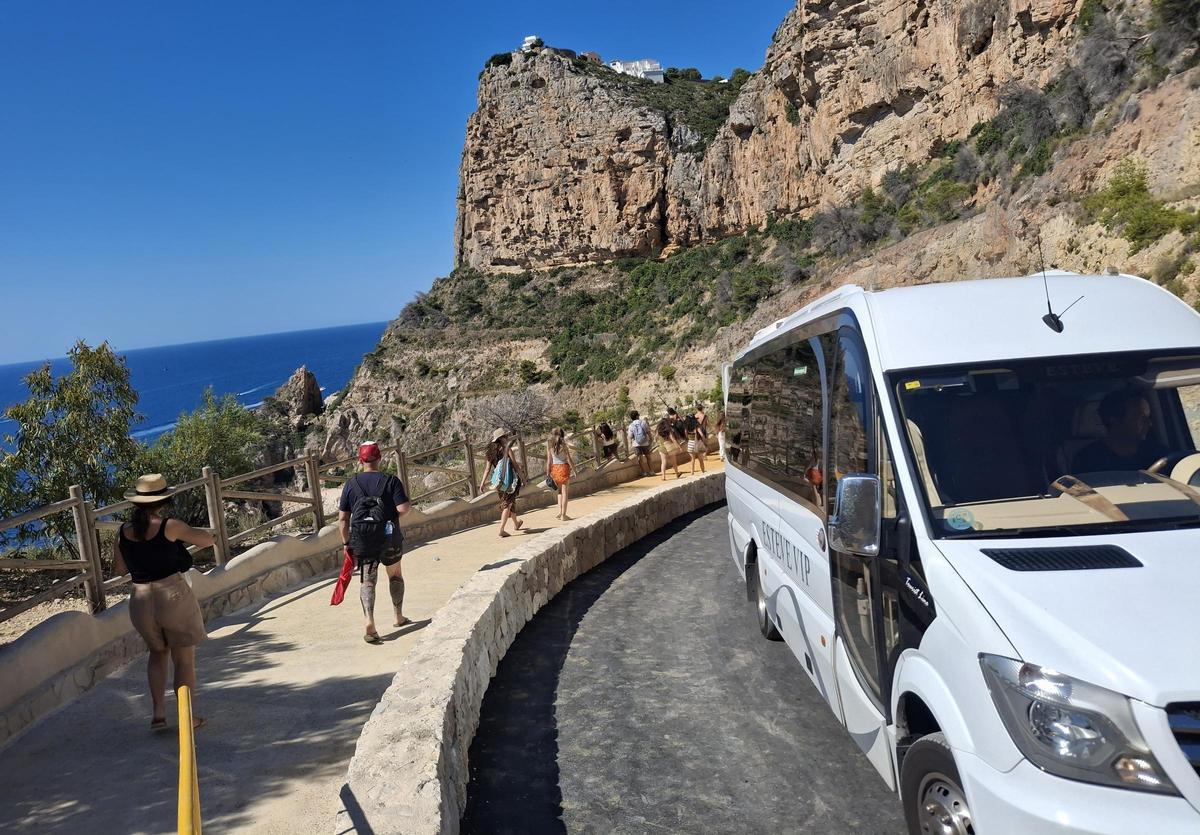 La acera creada ahora en la cala del Moraig da mucha seguridad a los bañistas; en la imagen, el autobús sube por el carril de tráfico