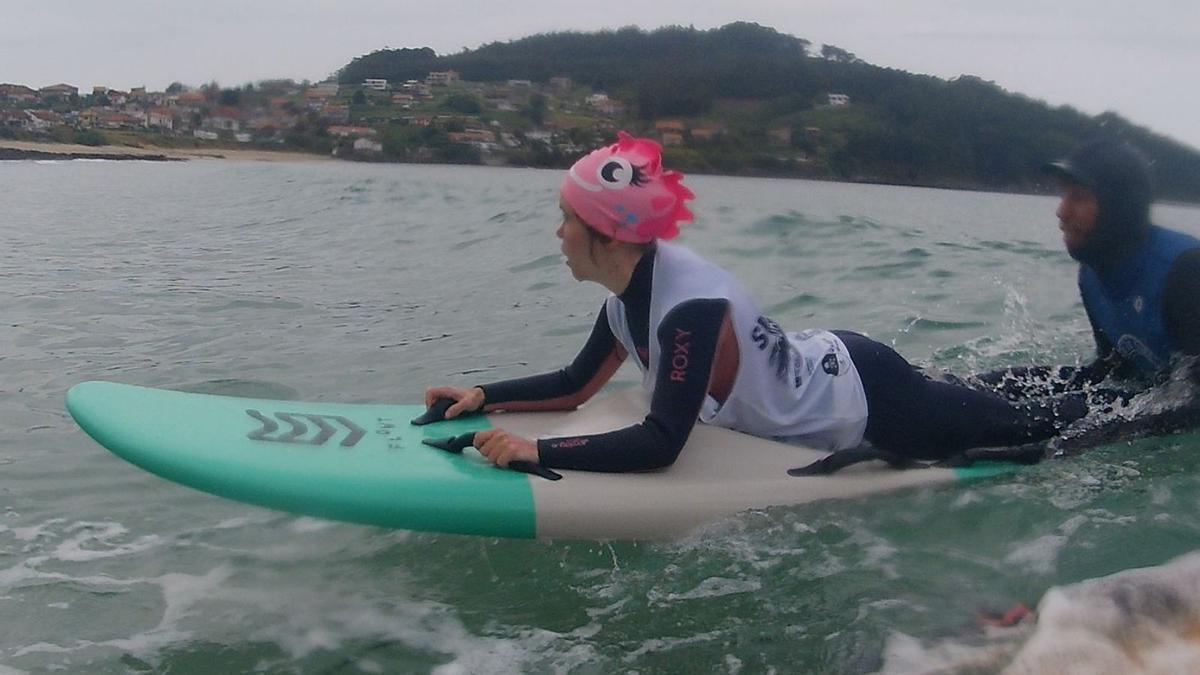 Una participante del proyecto de Surf Integración, con su monitor. // Foto cedida por La Fundación “la Caixa”.