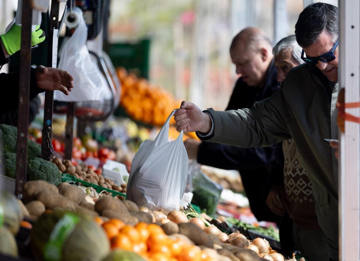 Gente comprando frutas y hortalizas.
