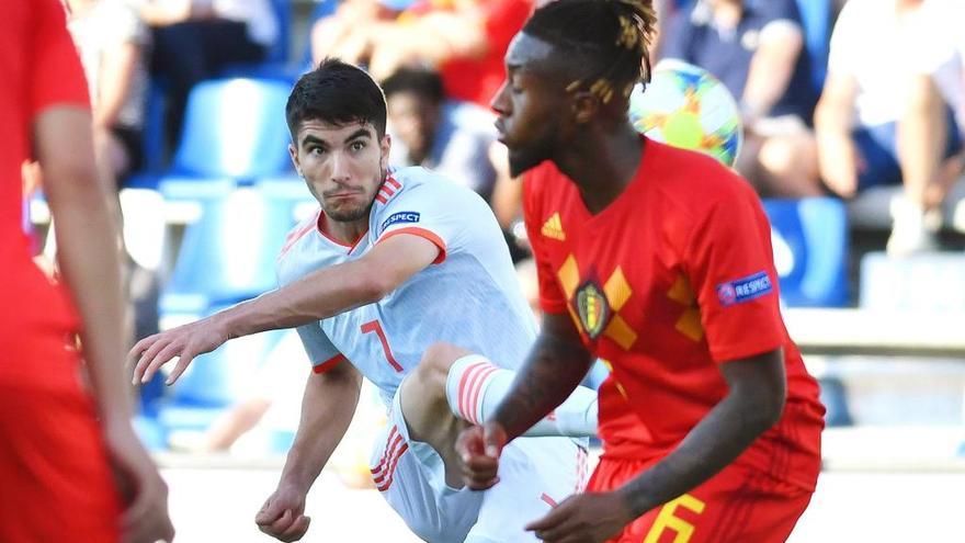 Carlos Soler chuta ante el centrocampista belga Samuel Bastien en un partido de la fase de grupos.