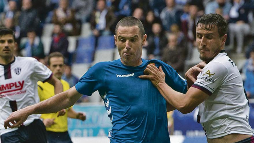 Cervero pelea un balón con un defensa del Huesca.