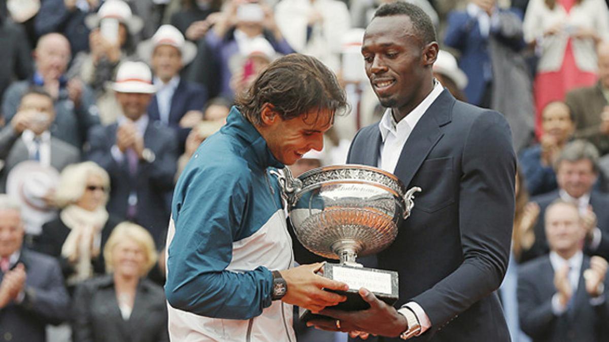 Rafa Nadal recoge el trofeo que lo acredita como campeón de Roland Garros de manos de Usain Bolt