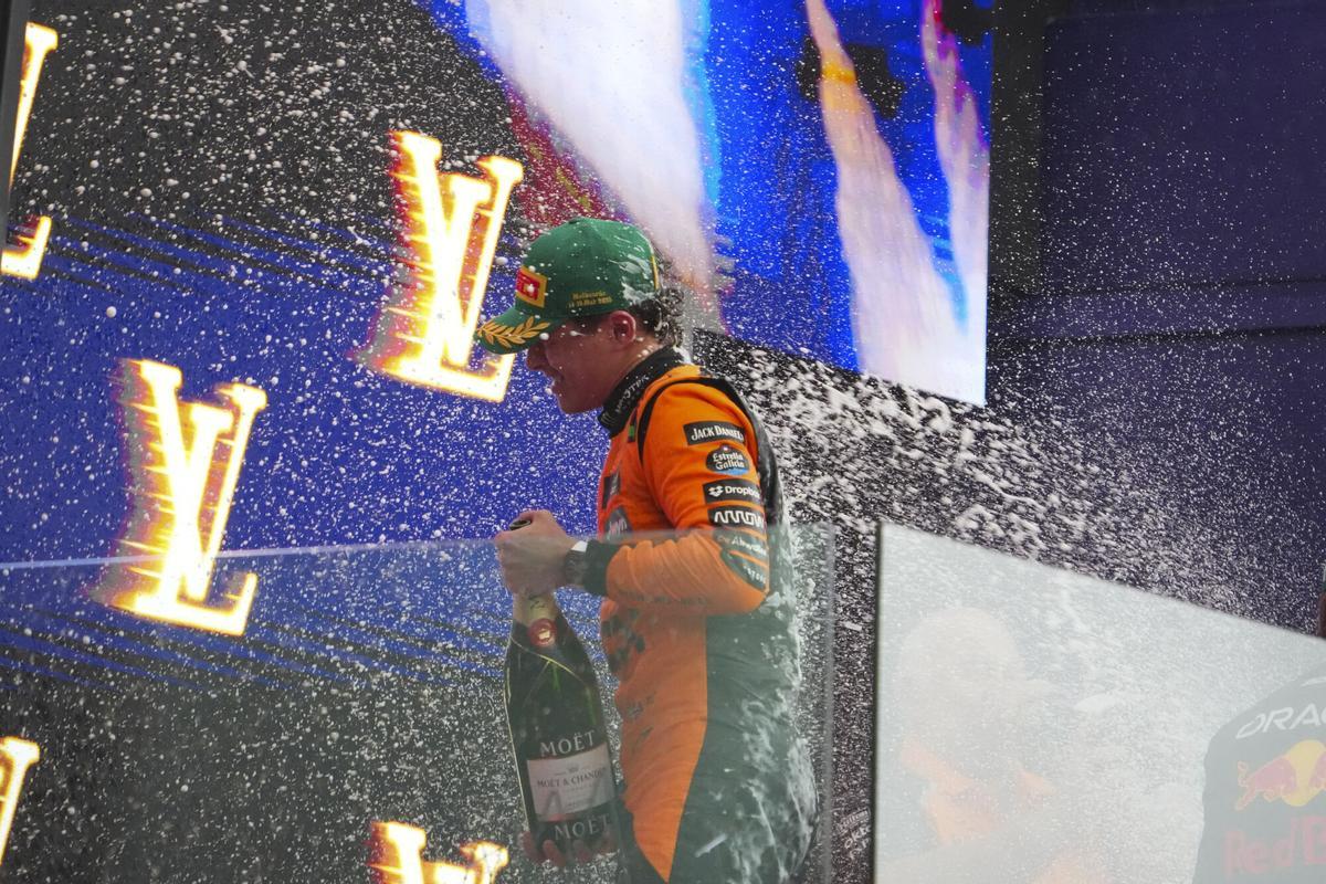 McLaren driver Lando Norris of Britain is sprayed in champagne as he celebrates on the podium after winning the Australian Formula One Grand Prix at Albert Park, in Melbourne, Australia, Sunday, March 16, 2025. (AP Photo/Scott Barbour)