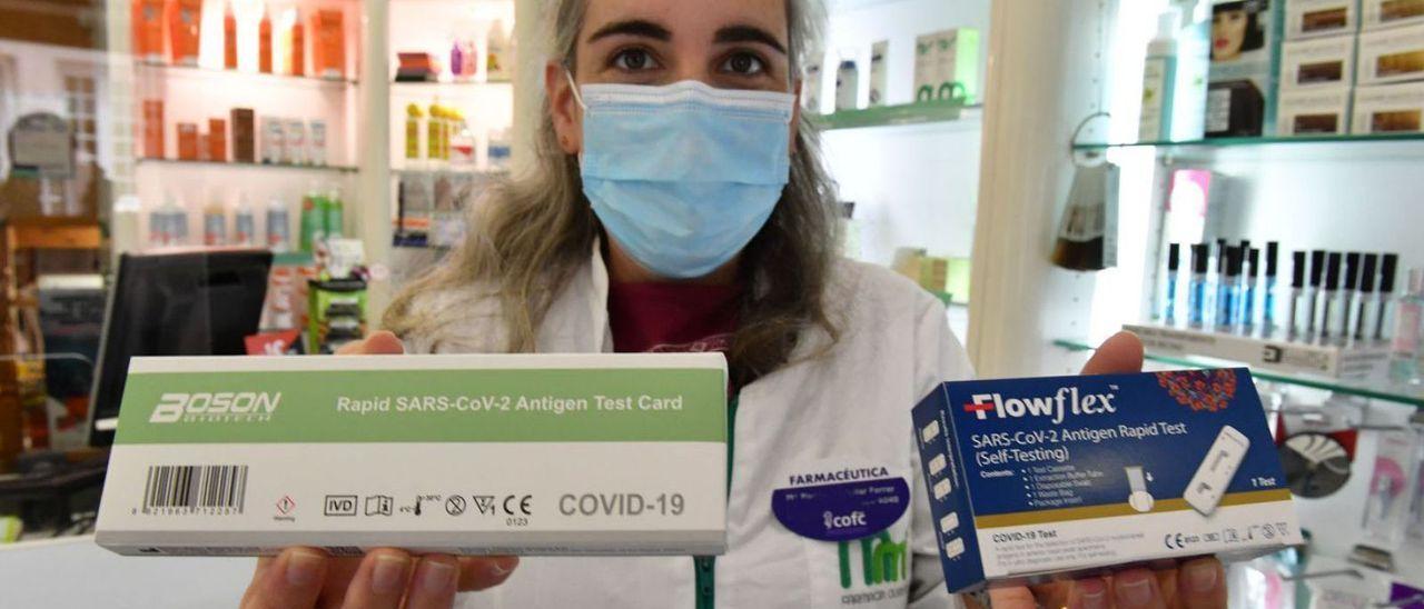 Una farmacéutica muestra test de antígeno Covid-19, cuya venta se ha vuelto a disparar.