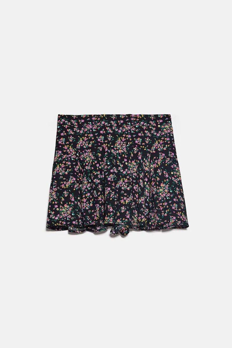 Falda bermuda negra con estampado de flores lilas de Zara. (Precio: 22,95 euros. Precio rebajado: 15,99 euros)