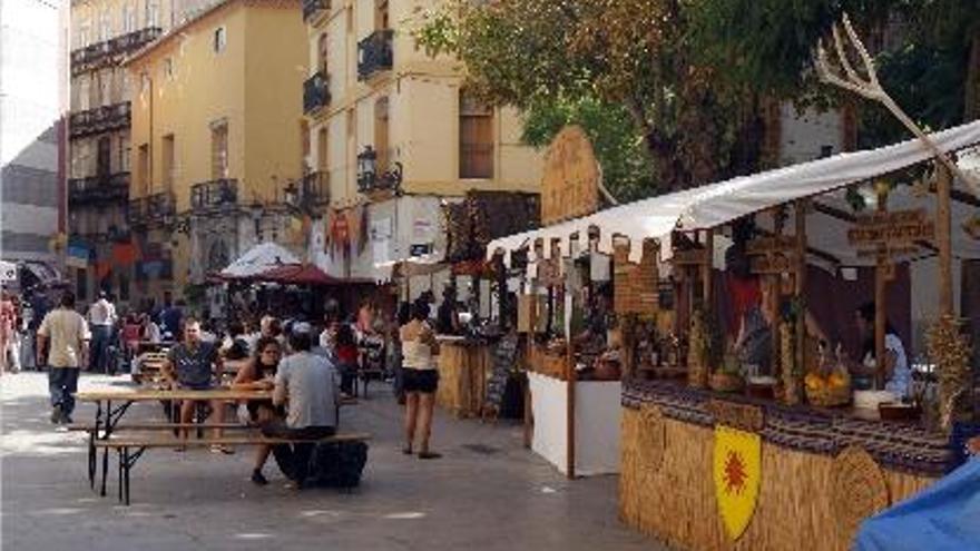 El mercadillo, con varias mesas para comer en la plaza.