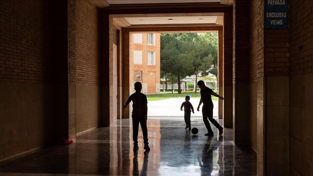 Unos niños juegan a fútbol en una zona privada de la comunidad de vecinos de Barcelona, el 18 de marzo del 2020