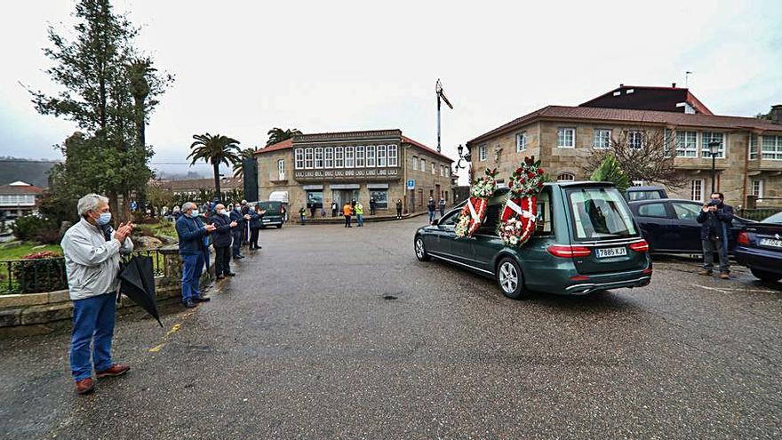 Vecinos aplauden al paso del coche fúnebre. |   // ANXO GUTIÉRREZ