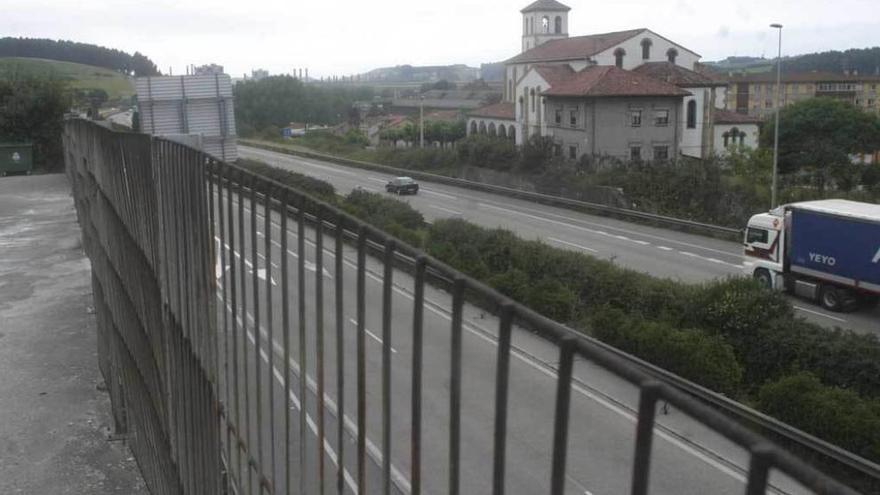 Vehículos circulando por la autopista &quot;Y&quot;, con la iglesia de Trasona al fondo.