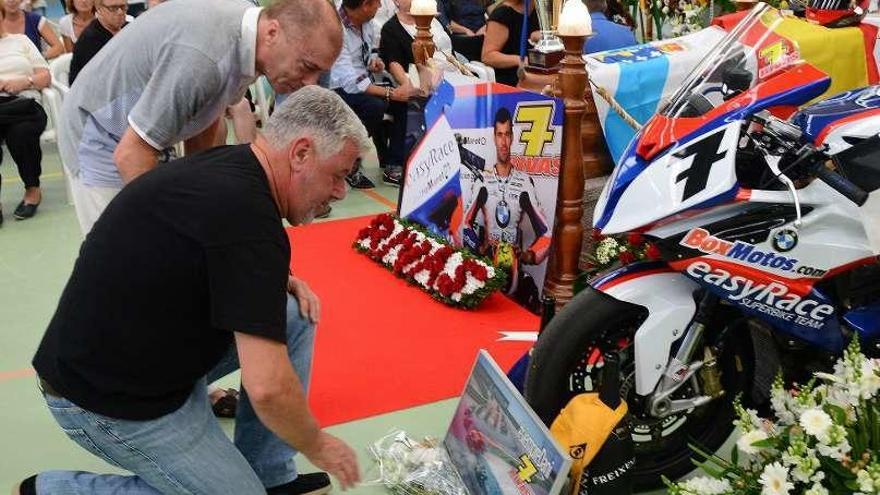 El padre de Dani Rivas hace una ofrenda en la capilla ardiente.