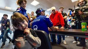 La pequeña Alice Oliveira Pimenta, de 4 años, le hace un guiño al fotógrafo, mientras su padre atiende a la prensa.