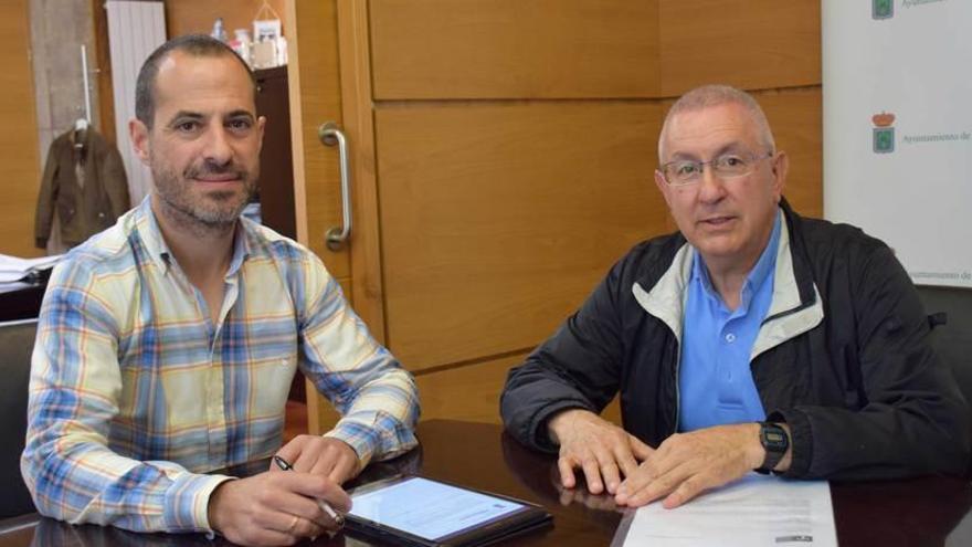 El alcalde, Ángel García, y el párroco, Segundo Gutiérrez, ayer, firmando el convenio.