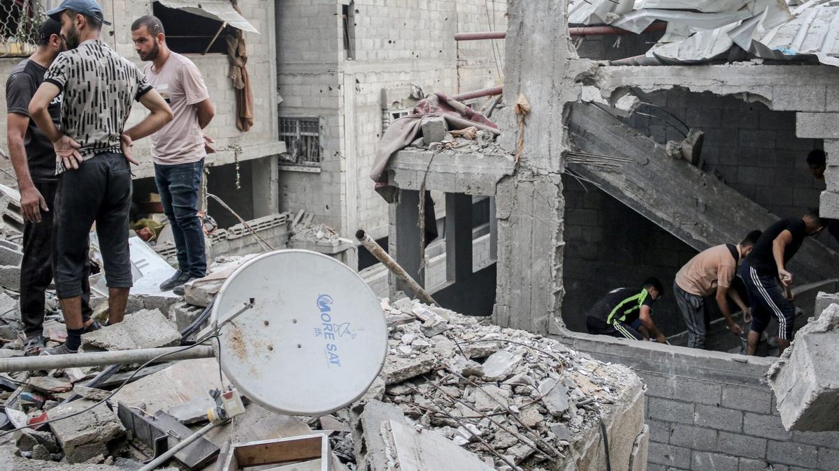 Palestininos inspeccionan los daños de un bombardeo de israel en  el campamento de Nuseirat (Gaza).