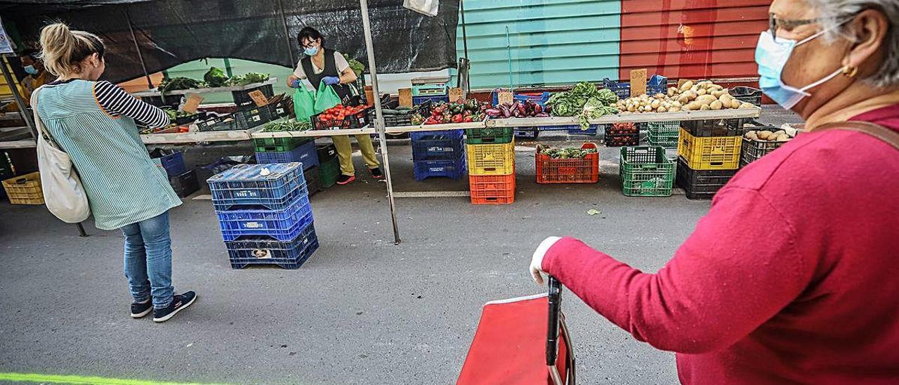 Una mujer espera su turno para comprar fruta y verdura en uno de los puestos de Rafal.
