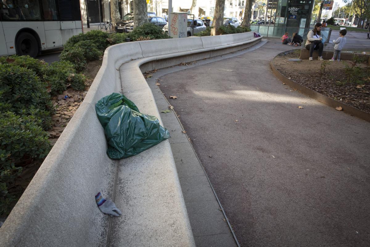 Basura abandonada en un banco de los Jardinets de Gràcia