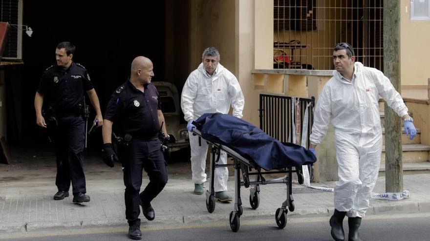 Operarios de los servicios funerarios trasladan el cadáver del fallecido.