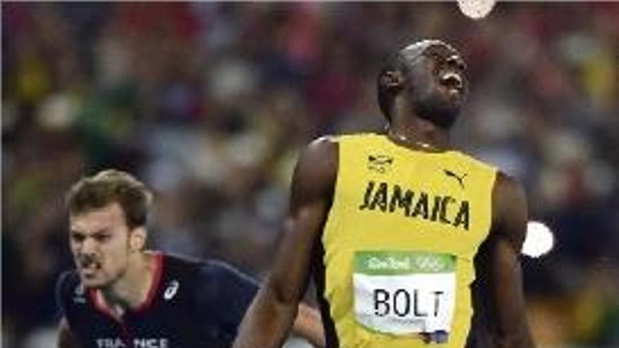 Usain Bolt en el moment de creuar, primer, la línia de meta.