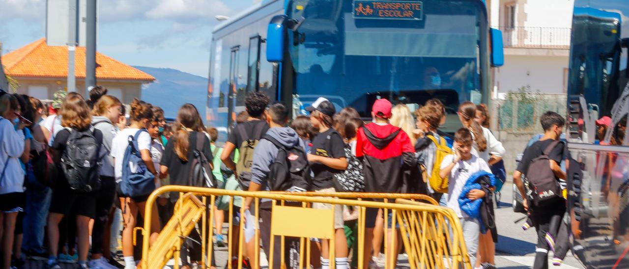 Niños subiendo a un autobús, junto al campo de fútbol del San Martín.