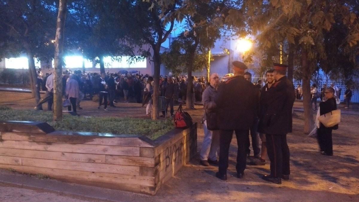 Dos Mossos parlen amb diverses de les persones concentrades a les 7.15 hores a l’institut Laia Arquera del barri del Pla d’en Boet de Mataró. Els anuncien que no retiraran les urnes. 