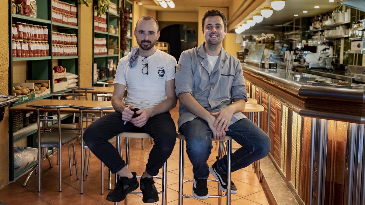 El cocinero Adrià Cartró y Joan Romans. jefe de sala, en la entrada de los Ultramarinos Marín.