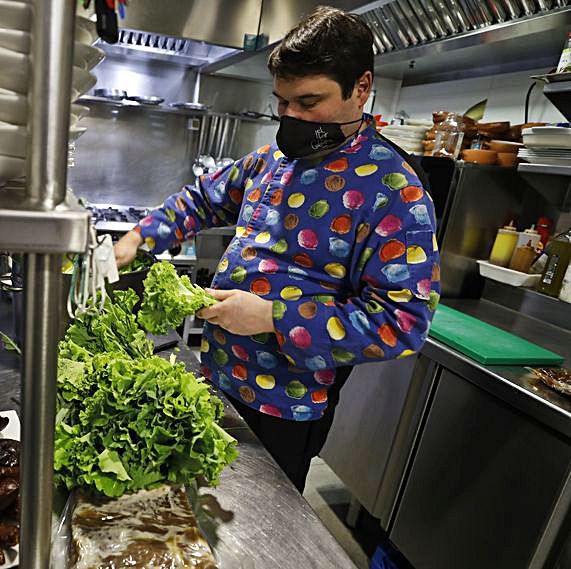 Juan Cuesta prepara los ingredientes para elaborar el pote en su negocio de la plaza de la Catedral.