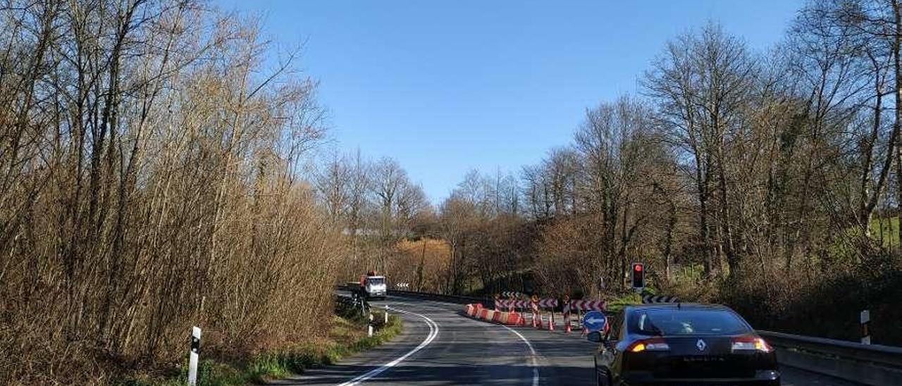 Coches parados en el semáforo que regula el tráfico, en Ceceda.