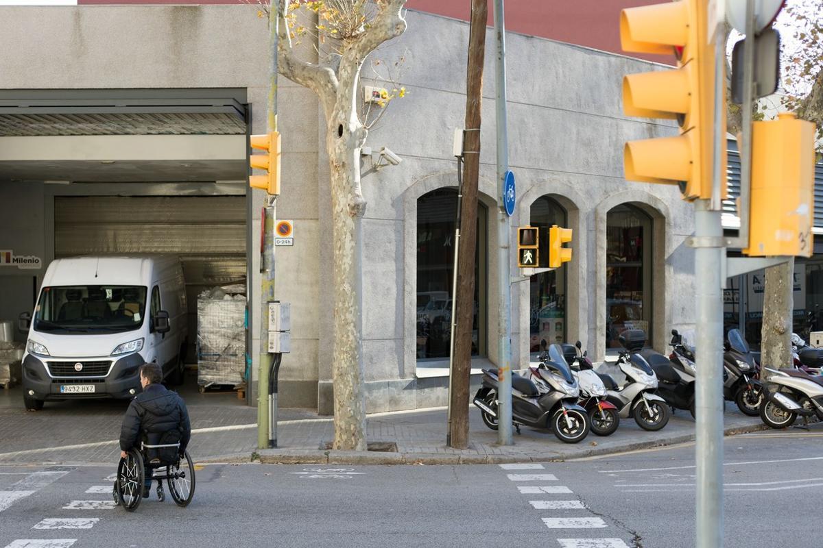 Una persona en silla de ruedas ante los obstáculos del paso peatonal