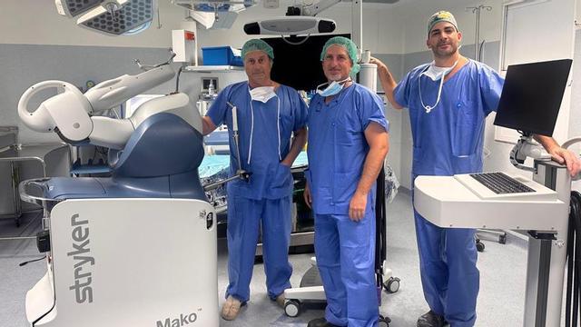 De izquierda a derecha, los doctores Néstor Moreno, Juan Pedro Rodríguez y Tomás Roca, especialistas en traumatología y cirugía ortopédica del Hospital Vithas  Las Palmas posan junto al robot Mako. |