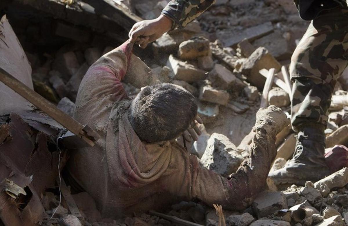 Los miembros del ejército nepalí rescatan un cadáver desde el interior de un edificio que se derrumbó en el terremoto Sábado en Bhaktapur, en las afueras de Katmandú .