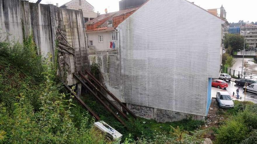 Talud del camino de Raposeiras, tras los edificios iniciados en esta urbanización inacabada.